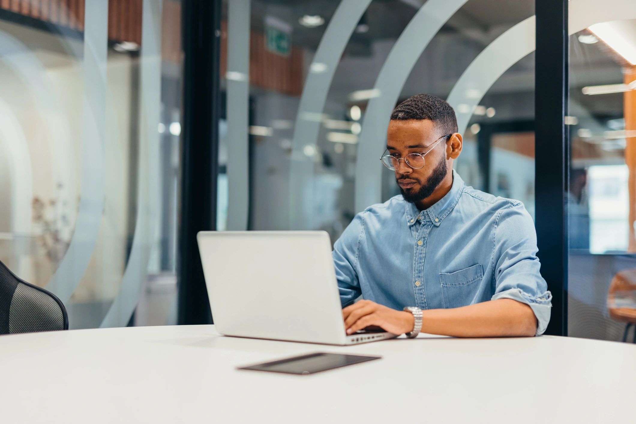 Editor working on a laptop in a bright modern workspace